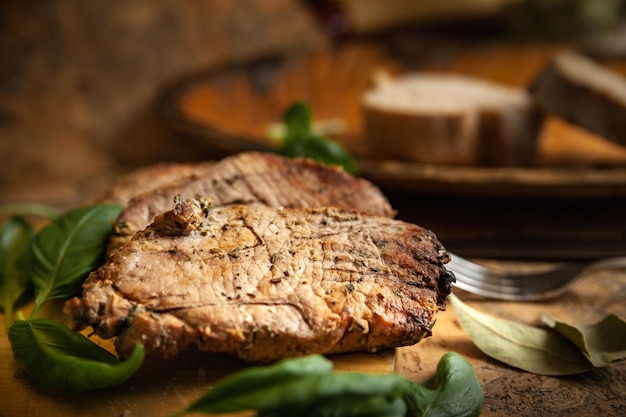 Carne frita com especiarias na grelha decorada com fundo de madeira de manjericão