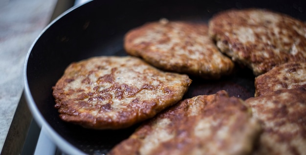 Carne frita en una sartén. Chuletas De Ternera Frita Para Hamburguesas. Cómo hacer una hamburguesa.