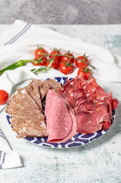 Carne Fumegada a Frio Prato de antipasto Prato de carne assada salame e bacon em fundo cinza