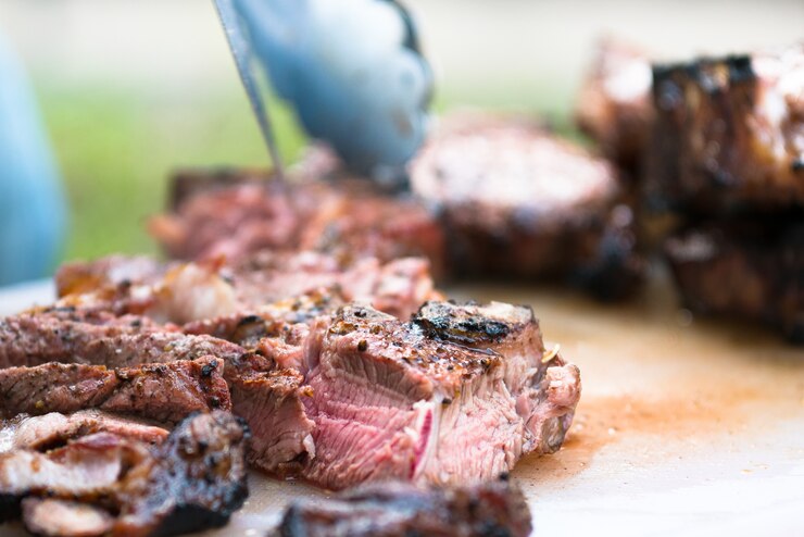 carne grelhada cortada em placa de corte de plástico