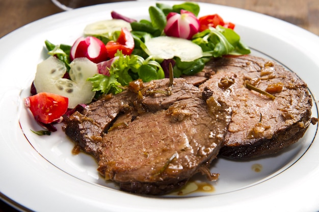 carne guarnecida com salada fresca, tomates, rabanetes e pepinos