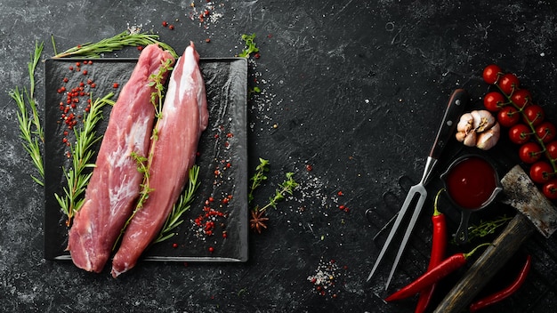 Carne Lombo de porco cru com especiarias em um fundo de pedra preta Vista superior Estilo rústico