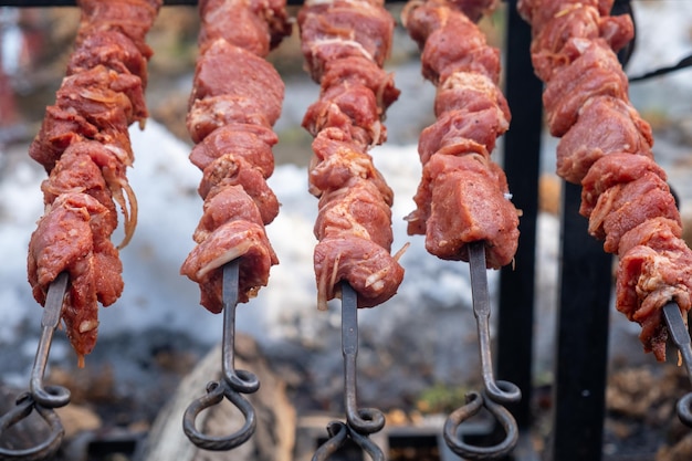 Carne marinada en brochetas para su posterior cocción. De cerca. Enfoque selectivo.