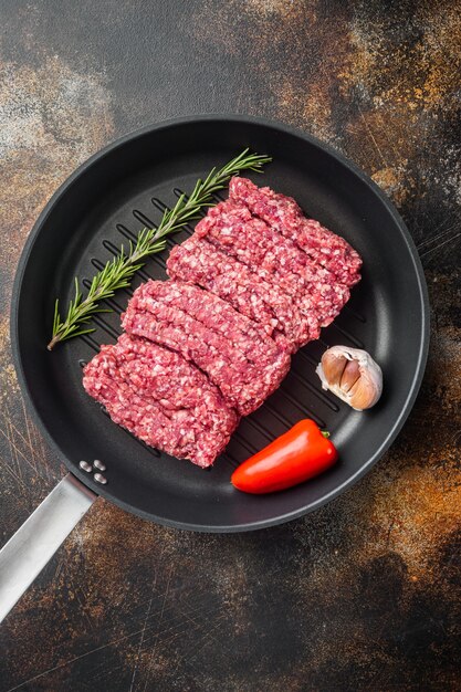 Carne moída de carne fresca picada, em fundo rústico escuro antigo, vista de cima plana lay