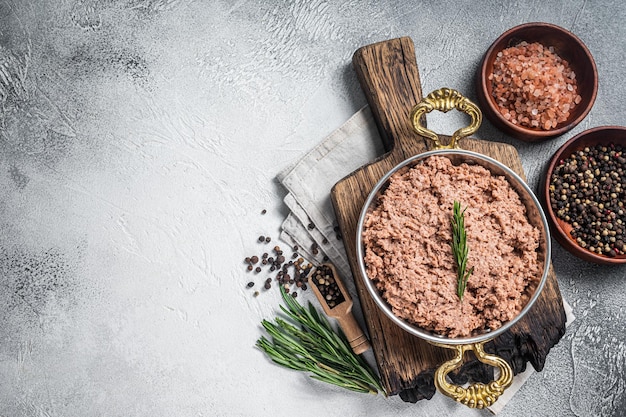 Carne moída vegan não cozida carne crua à base de plantas com tomilho na frigideira fundo branco vista superior espaço para cópia