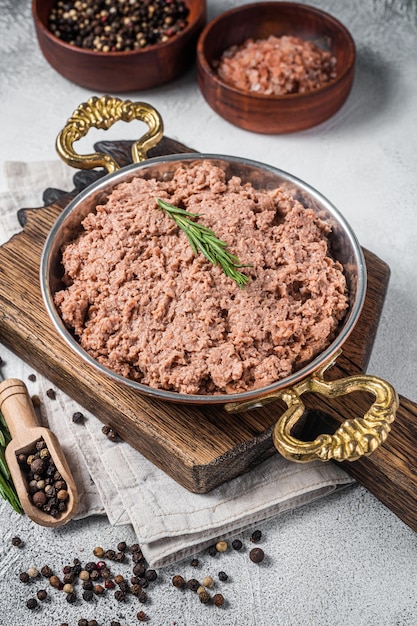 Carne moída vegana crua, carne crua à base de plantas com tomilho na frigideira. Fundo branco. Vista do topo.