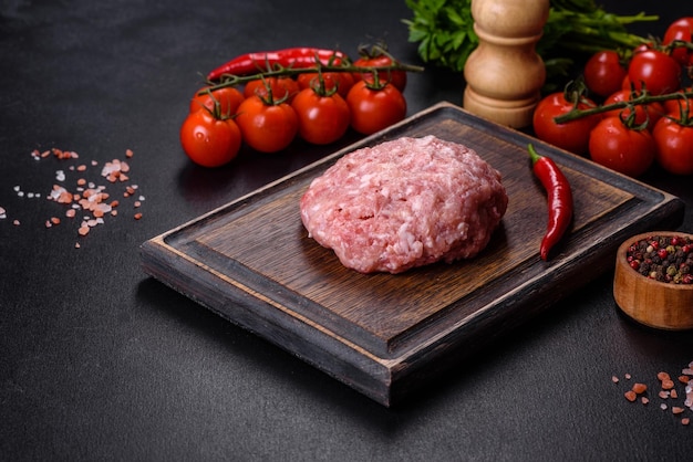 Carne molida con ingredientes para cocinar sobre fondo negro