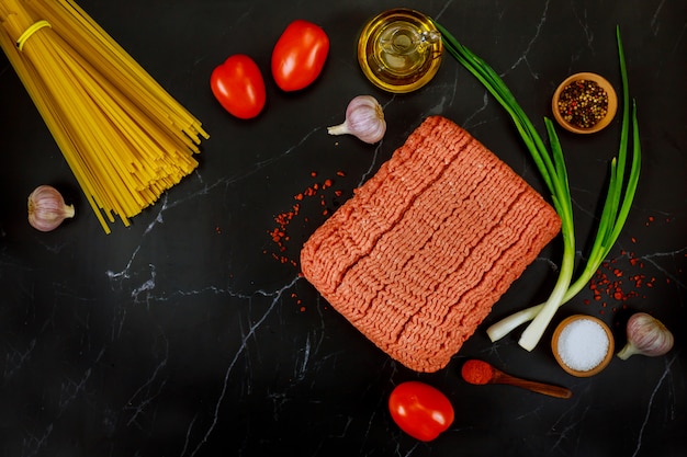 Carne molida, pasta de espagueti, ajo, tomate y cebolla.