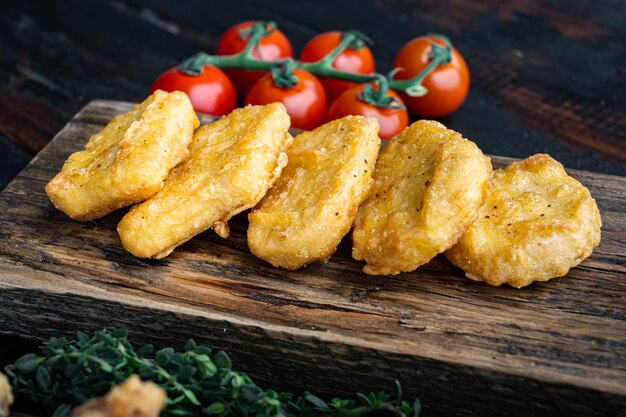 Carne de nuggets de pollo crujiente frito en la vieja mesa de madera oscura.