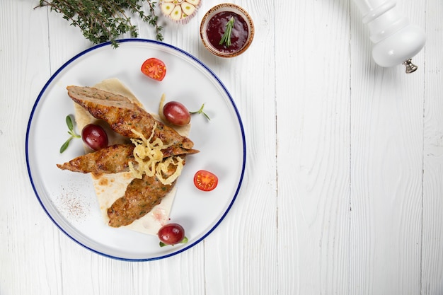 Carne en pan de pita con ajo sobre un fondo de madera