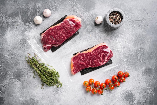 Carne en un paquete, sobre fondo de mesa de piedra gris, vista superior plana, con espacio de copia para texto