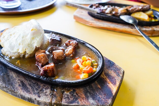 carne a la parrilla, bistec de res, servido en plato caliente