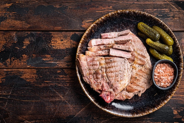 Carne a la parrilla Filetes de cerdo de filete de cuello en plato con pepinos encurtidos Fondo de madera Vista superior Espacio de copia