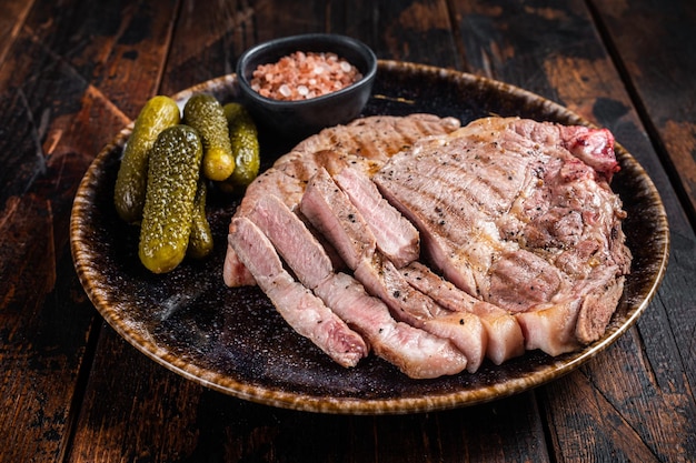 Carne a la parrilla Filetes de cerdo de filete de cuello en plato con pepinos encurtidos Fondo de madera Vista superior