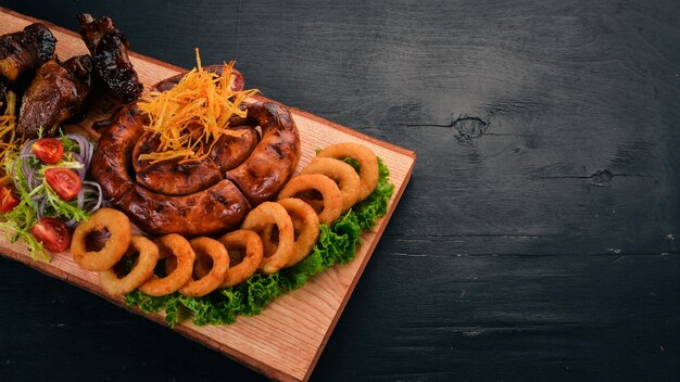 Carne a la parrilla en el tablero Costillas de salchicha y verduras frescas En una mesa de madera Vista superior Espacio de copia