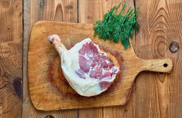 Foto carne de pato cruda en forma de piernas sobre un fondo de madera