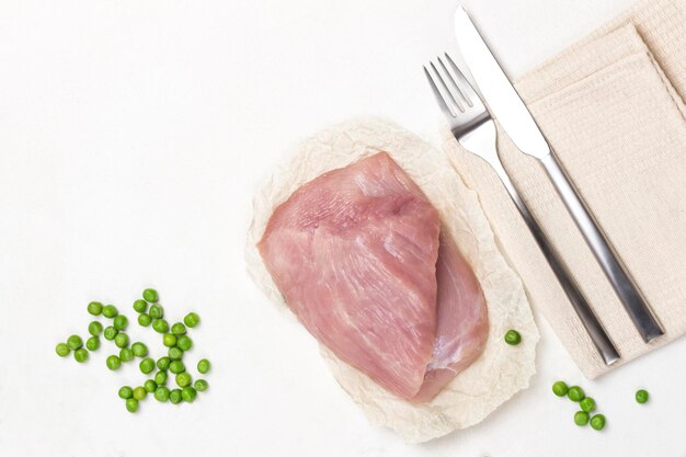 Carne de pavo dietética con guisantes verdes Cuchillo y tenedor en servilleta