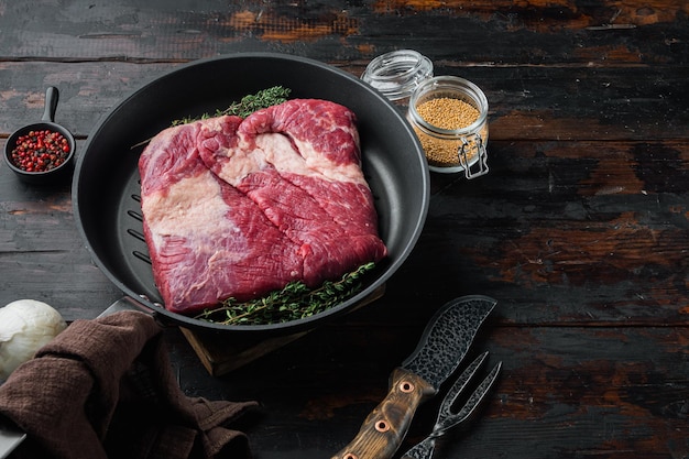 Carne de pecho de ternera cruda cortada en cruz sobre un fondo de mesa de madera oscura antiguo con espacio de copia para texto