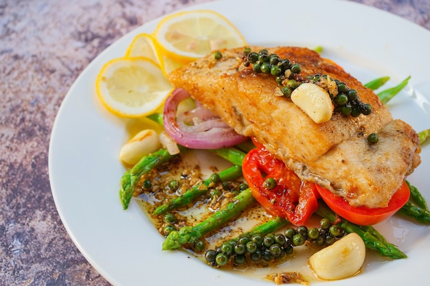 carne de pescado lubina con verduras y limón