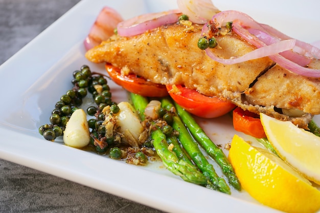 carne de pescado lubina con verduras y limón