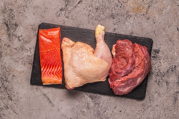 Carne, pescado, pollo en el tablero, vista superior.