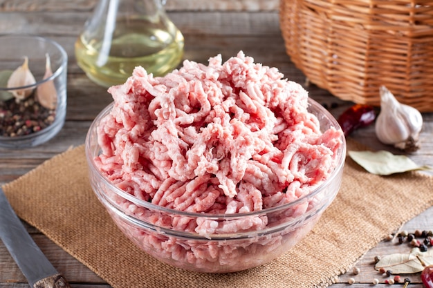 Carne picada de cerdo fresca en un plato sobre una mesa de madera