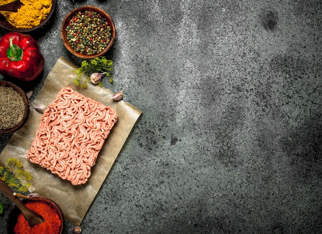 Carne picada com vários temperos e ervas em um fundo rústico