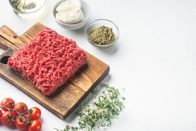 Carne picada cruda con especias, verduras y hierbas y albóndigas, en piedra blanca