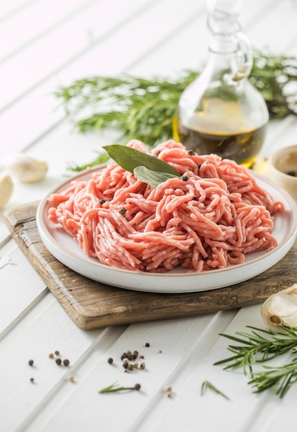 Carne picada de carne crua fresca com ervas e alecrim na placa de madeira em um lugar de receita de menu de banner de fundo leve para vista superior de texto