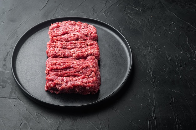 Carne picada de carne, em fundo preto com espaço de cópia para texto