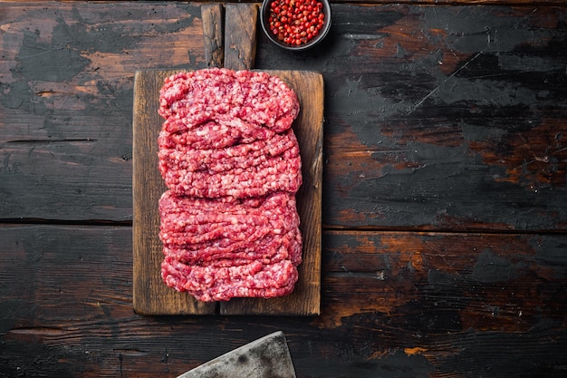 Carne picada de carne, na velha mesa de madeira escura, vista de cima plana com espaço de cópia