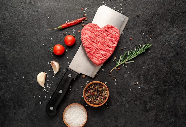 Carne picada em forma de coração em uma faca em um fundo de pedra