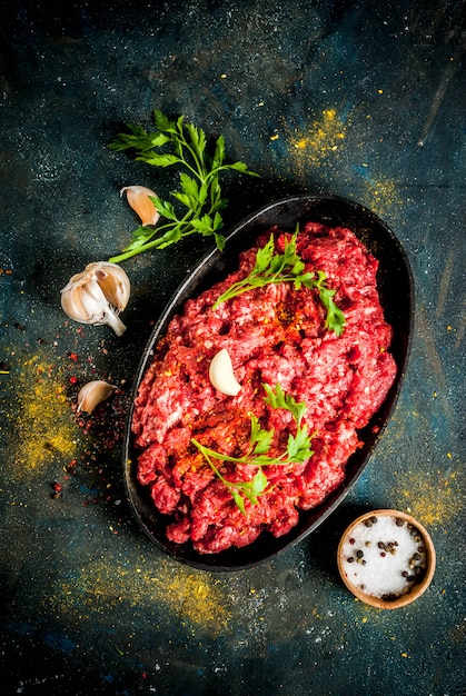 Carne picada con especias y hierbas frescas para cocinar.