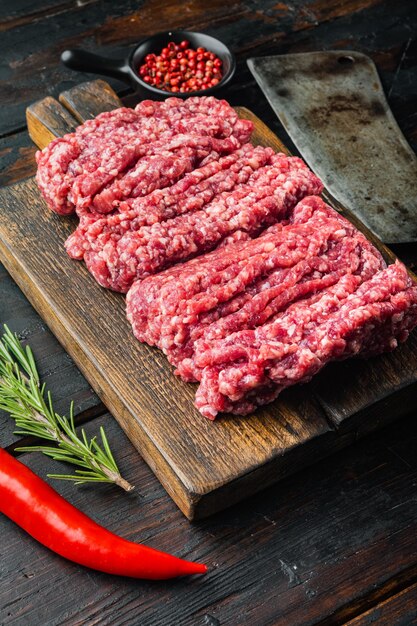 Carne picada fresca, carne molida de res, sobre la vieja mesa de madera oscura.