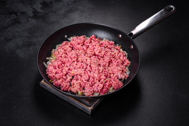 Carne picada fresca cruda con cebolla en una sartén Cocinar comida saludable y sabrosa