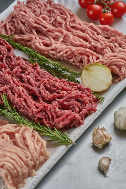 Carne picada fresca variada de diferentes tipos de carne en una carnicería en una bandeja