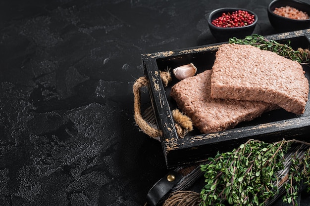 Carne picada vegana a base de plantas crudas con hierbas Fondo negro Vista superior Espacio de copia