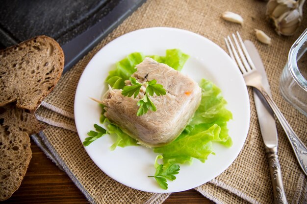 Foto carne de pollo cocida en caldo de gelatina de carne en un plato