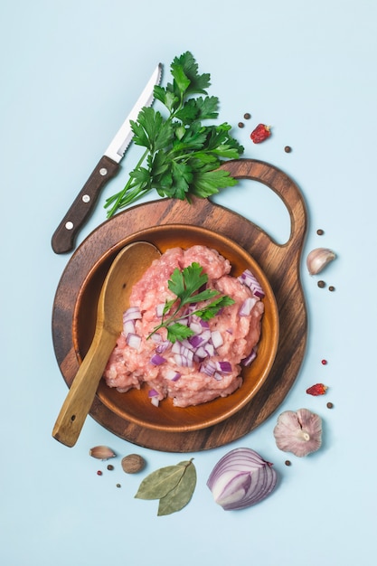 Carne de pollo cruda picada en un tazón con especias