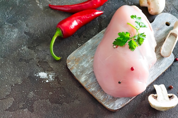 Foto carne de pollo cruda sobre corte de madera