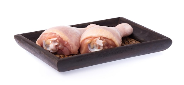 Foto carne de pollo cruda en tejido de bandeja aislado sobre fondo blanco.