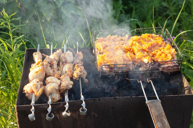 La carne de pollo se fríe a la parrilla y en brochetas.Una caja de hierro con brasas en el jardín en el verano.