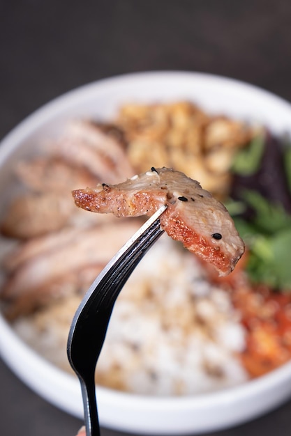 Foto carne en primer plano en el fondo de un cuenco con carne de ternero de arroz y verduras