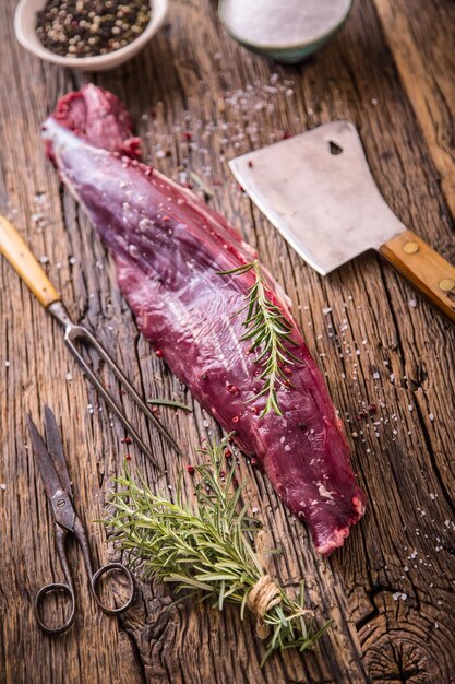 Carne de res cruda bistec de filete de res crudo en una tabla de corte con sal de pimienta de romero en otras posiciones