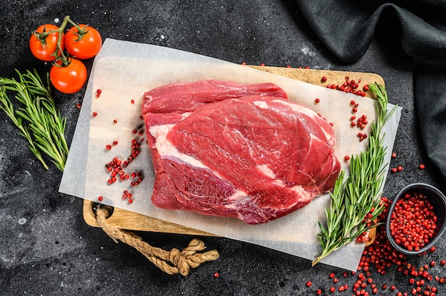 Carne de res cruda pechuga cortada sobre una tabla para cortar madera