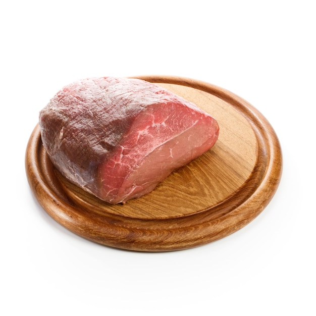Carne de res cruda sobre tabla de cortar de madera, primer plano, fondo blanco