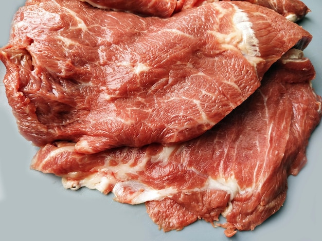 Carne de res fresca Grandes trozos de carne cruda sobre un fondo gris Primer plano de fibras de carne