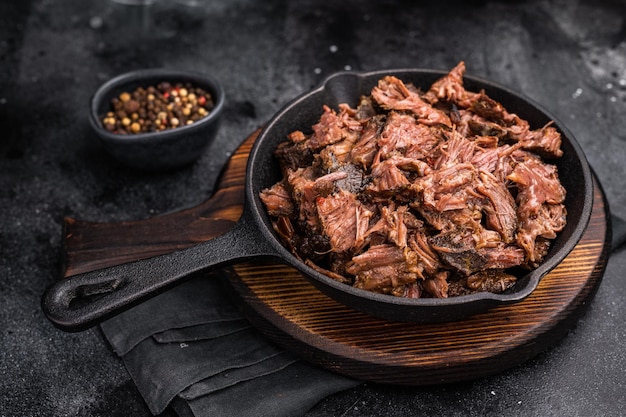 Carne de res a la parrilla tradicional, cocida lentamente, cocida en un fumador, fondo negro, vista de arriba