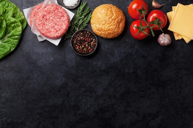 Carne de res picada cruda e ingredientes para hamburguesas