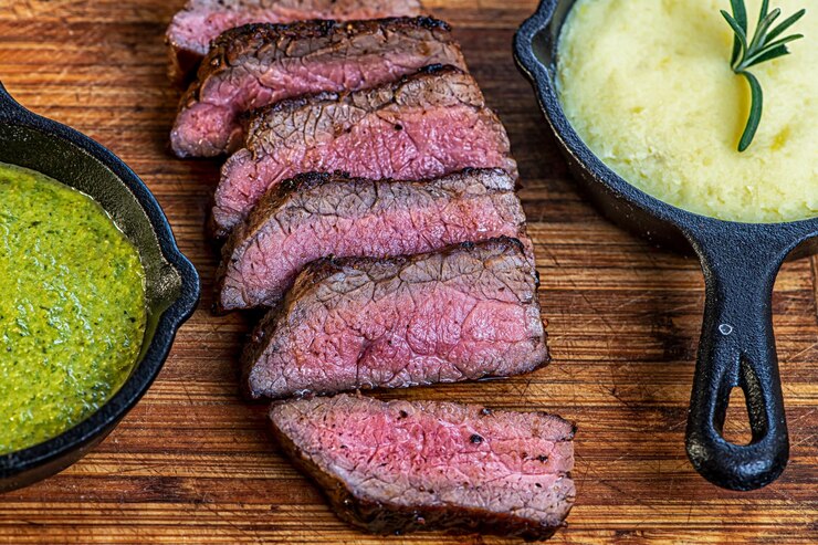Foto carne de res, sartén, ajo, romero, espinaca, pesto, patatas y musgo.